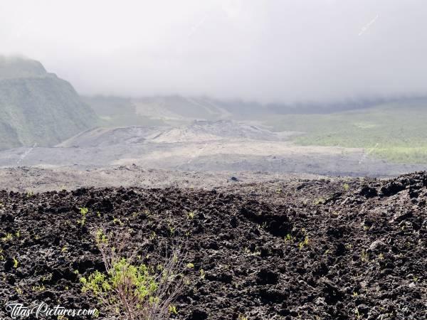 Photo Coulée de Lave : Coulée de lave refroidie, avec le Volcan derrière les nuages.
À cet endroit, la lave est passée par dessus la route à plusieurs reprises déjà 😅c, Coulée de Lave, volcan