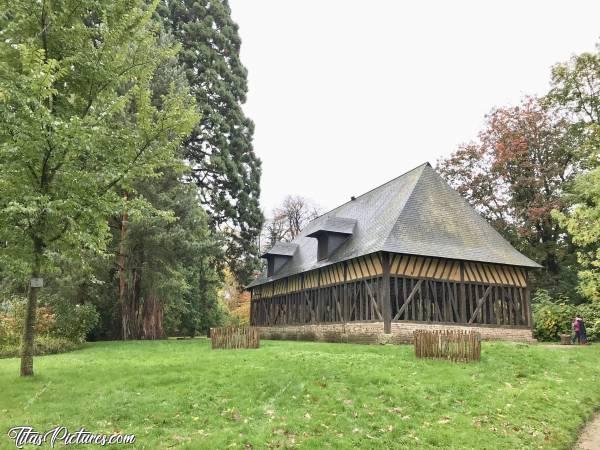 Photo Bâtisse à Colombage : Belle Bâtisse à Colombage dans le Jardin des Plantes de Rouen. À l’intérieur se trouve une vieille meule en pierre identique à celle qui se trouve à l’extérieur. L’air peut circuler librement au travers des murs qui sont parsemés d’ouvertures.c, Bâtisse à Colombage, Jardin des Plantes, Rouen