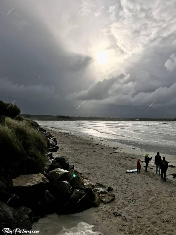 Photo Le Dossen : La Plage du Dossen à Santec. Beau jeu de lumière au travers des nuages ce jour-là 😍 Cette grande plage très exposée au vent, est très appréciée des sportifs : Surfeurs, Kitesurf, Chare-à-voile, Windsurf.c, Plage du Dossen, Santec, Rochers de protection