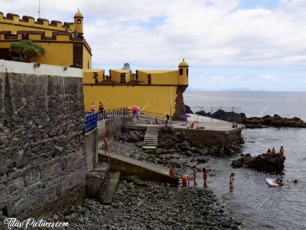 Photo Fortaleza de São Tiago : Toute petite plage de galets, dans le vieux Funchal, au pied de la Forteresse de São Tiago. Le ciel était couvert, mais il faisait très lourd 🥵
Résultat : ça donne une drôle d’ambiance à cette photo, avec ce contraste de couleurs… 😅c, Fortaleza de São Tiago, Forteresse de São Tiago, Funchal