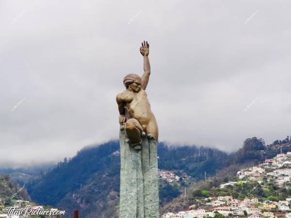 Photo Monument à Autonomia : Monument en souvenir de l’autonomie. Il s’agit d’une sorte d’obélisque, avec à son sommet une femme en bronze donnant l'impression d'en sortir. Il est situé sur la place éponyme dans le prolongement de l'avenida de Mar. A sa base des dalles sont éparpillées comme si le monument venait de sortir de terre.c, Monument à Autonomia, Funchal, Madère