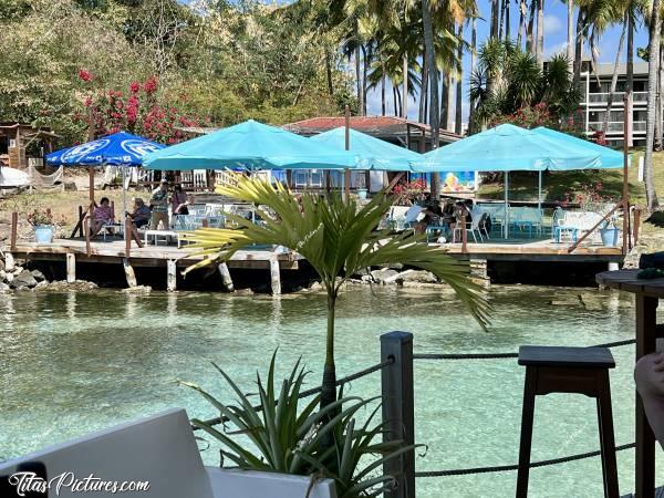 Photo Coco Bar Beach Club : Petit cocktail de fruits à l’ombre et entourée d’eau, au Coco Bar Beach Club à la Pointe du Bout des Trois-Îlets. Vue sur le petit restaurant-bar La Sirène. c, Tita’s Pictures, La Martinique, Coco Bar Beach Club, 